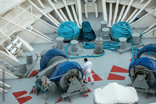Man getting ready to drop anchor on the deck of a ship.