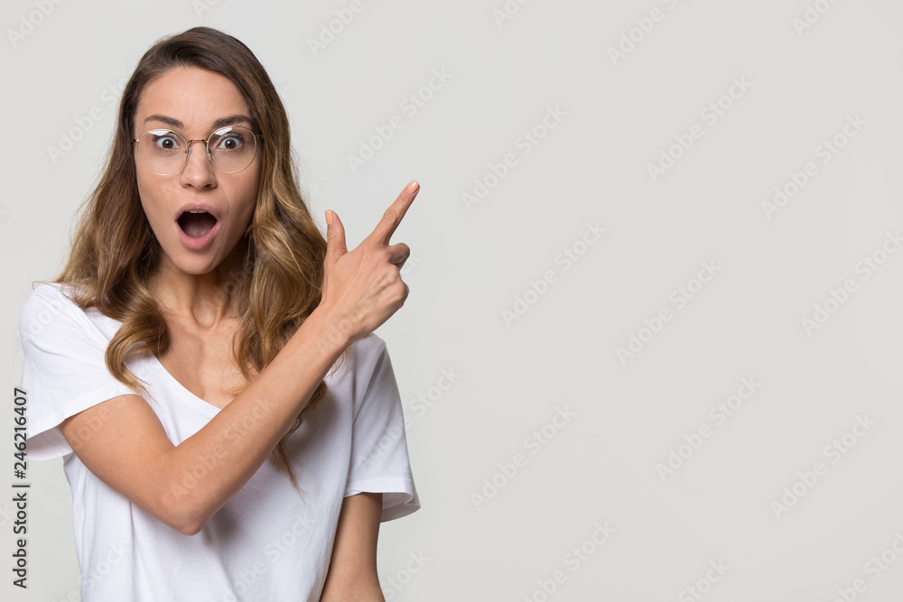 Amazed girl student wear optic glasses pointing finger at copy space looking at camera isolated on white studio blank background, surprised woman customer show aside advertise product service sale Amazed girl student wear optic glasses pointing finger at copy space looking at camera isolated on white studio blank background, surprised woman customer show aside advertise product service sale
