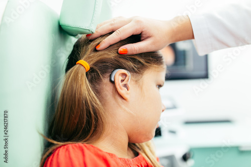 Young girl at medical examination or hearing aid checkup in otolaryngologist's office