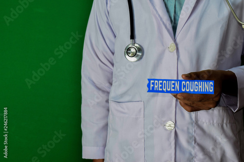 doctor standing on Green background. Hold the Frequen Coughing paper text. Medical and healthcare concept. photo