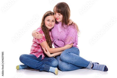 Two smiling and hugging sisters. Isolation on a white background.