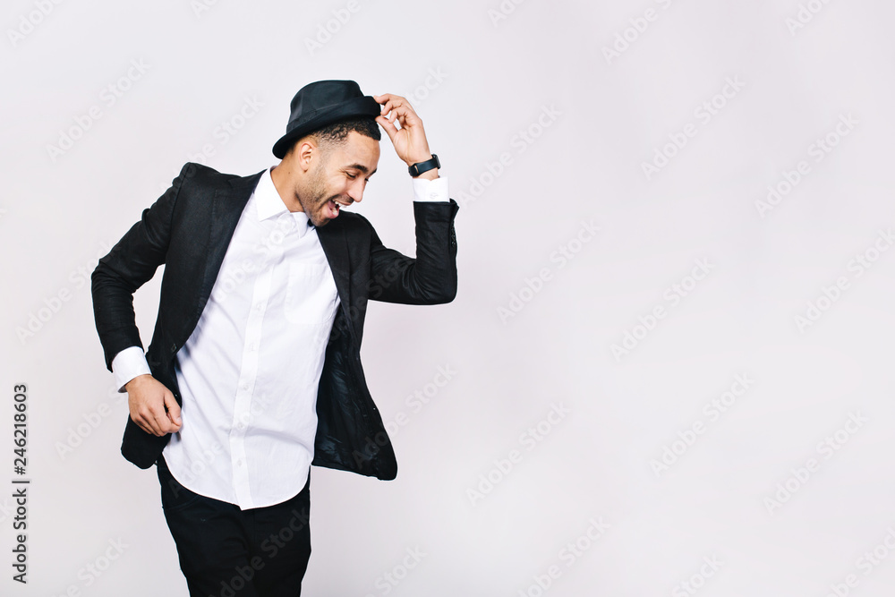Attractive young man in suit dancing, having fun on white background