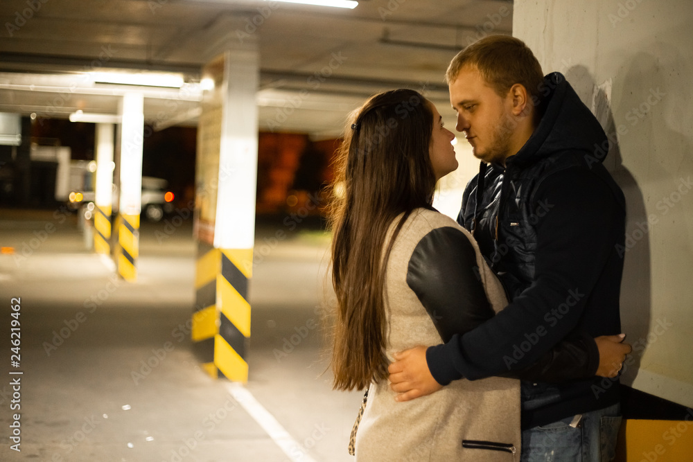 young couple in hugs on underground parking young couple in hugs on underground parking
