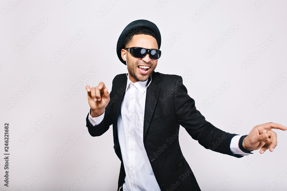 Stylish excited guy in suit, hat, black sunglasses having fun on white background. Leisure, weekends, cheerful mood, joy, happiness, dancer, singing modern businessman isolated Stylish excited guy in suit, hat, black sunglasses having fun on white background. Leisure, weekends, cheerful mood, joy, happiness, dancer, singing modern businessman isolated