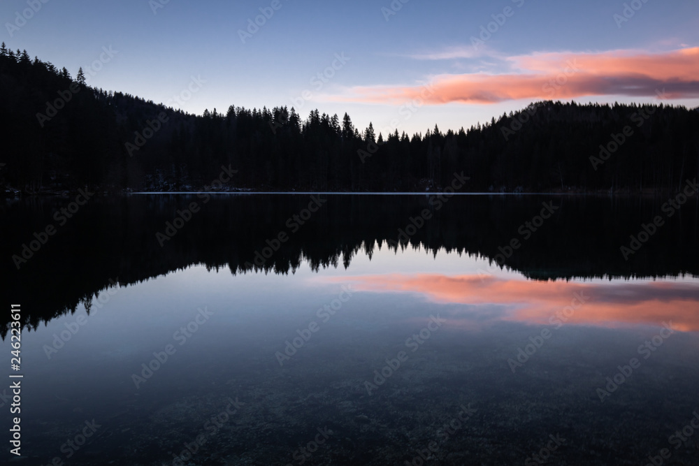 scenic mirror reflection on fusine lakes in sunset, italy