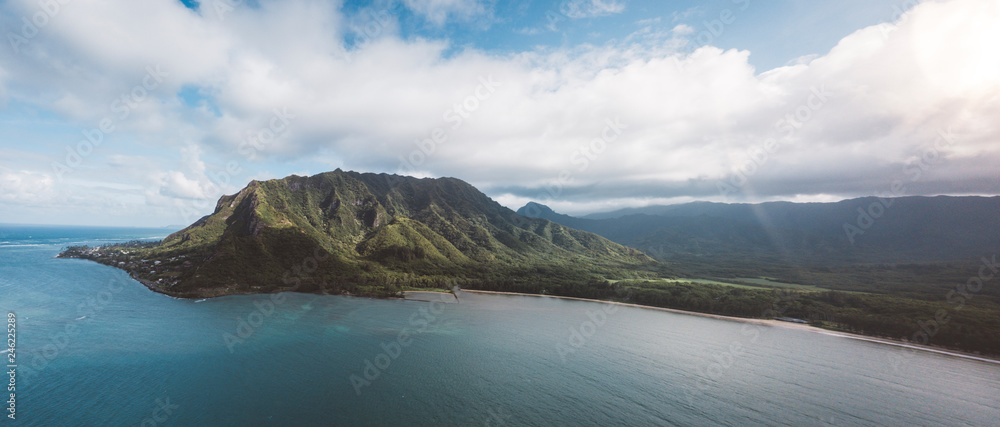 Scenic view of sea by mountains against cloudy sky Scenic view of sea by mountains against cloudy sky