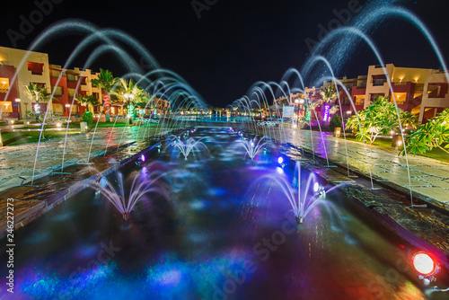 Ornate fountain lit up at night in luxury hotel resort