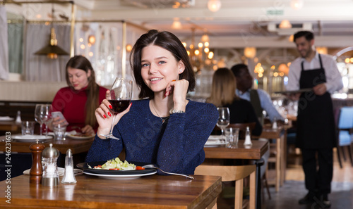 Happy girl alone in restaurant