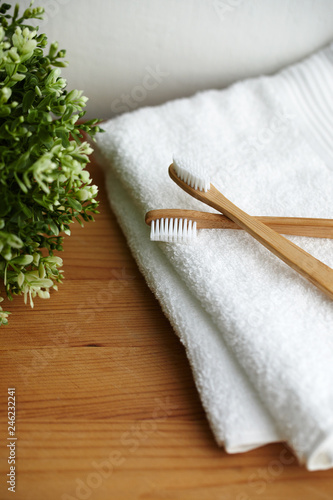 Fototapeta Naklejka Na Ścianę i Meble -  Two bamboo toothbrushes on white towel