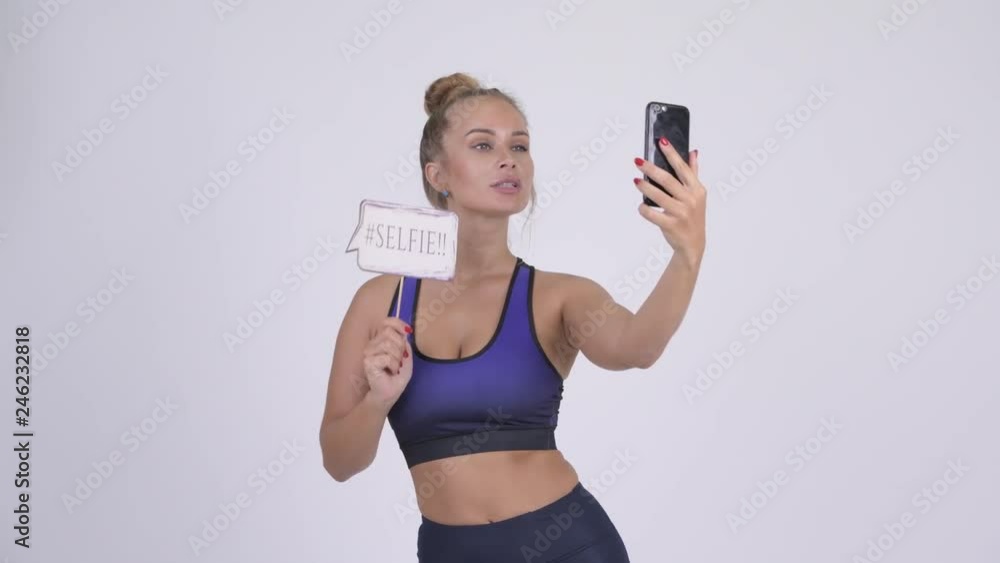 Young beautiful blonde woman taking selfie with paper sign Young beautiful blonde woman taking selfie with paper sign