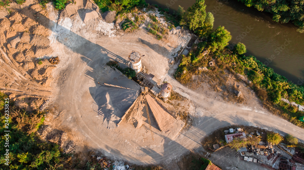 Naklejka premium aerial view of sand factory with trees around and rusty metal. Image by drone in Bulgaria