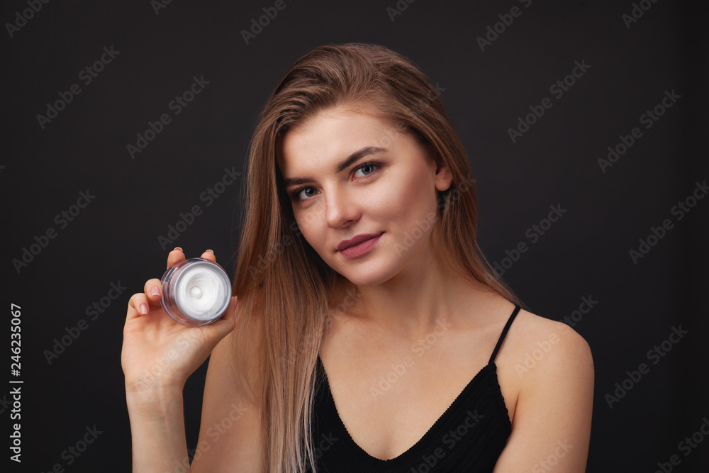 Young beautiful woman holding a jar of facial cream Young beautiful woman holding a jar of facial cream