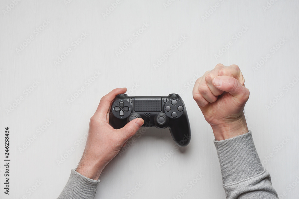 Hand hold new joystick isolated. Gamer play game with gamepad controller.  Gaming man holding simulator joypad. Person with keypad joystic in arms.  Sleeve hands hold toy equipment. Modern manipulator. Stock Photo