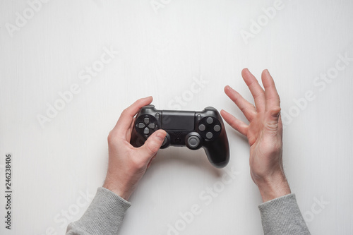 Hand hold new joystick isolated. Gamer play game with gamepad controller. Gaming man holding simulator joypad. Person with keypad joystic in arms. Sleeve hands hold toy equipment. Modern manipulator. © solidmaks