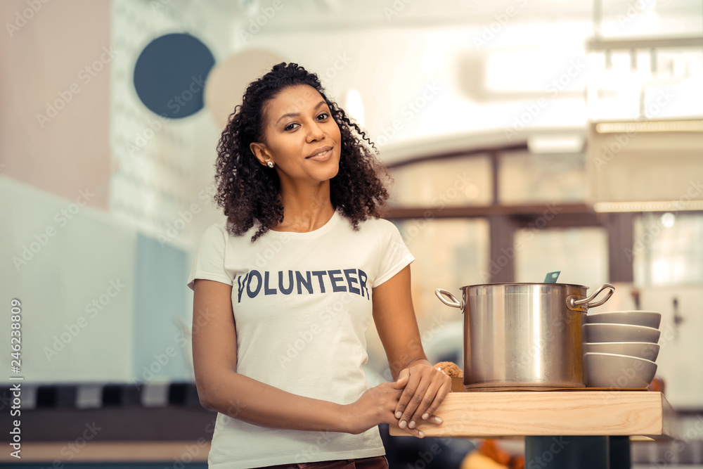 Joyful afro American woman standing near the saucepan Joyful afro American woman standing near the saucepan