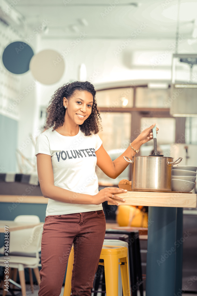 Joyful nice woman helping people as a volunteer Joyful nice woman helping people as a volunteer
