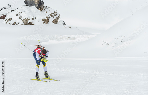 Winter sports. A participant in a biathlon competition, in a winter season in Spain, in a snowy landscape.