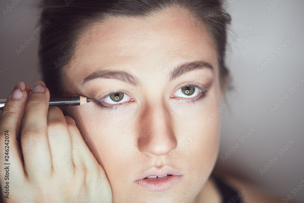 Young beautiful woman applying make-up by make-up artist. Process of making makeup. Young beautiful woman applying make-up by make-up artist. Process of making makeup.