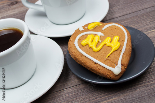 Two cups of coffee and heart cookies on a wooden table on Valentine s Day