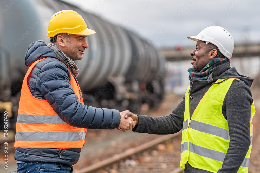 Successful handshake deal: multi-ethnic engineers reaching an agreement on construction site Successful handshake deal: multi-ethnic engineers reaching an agreement on construction site