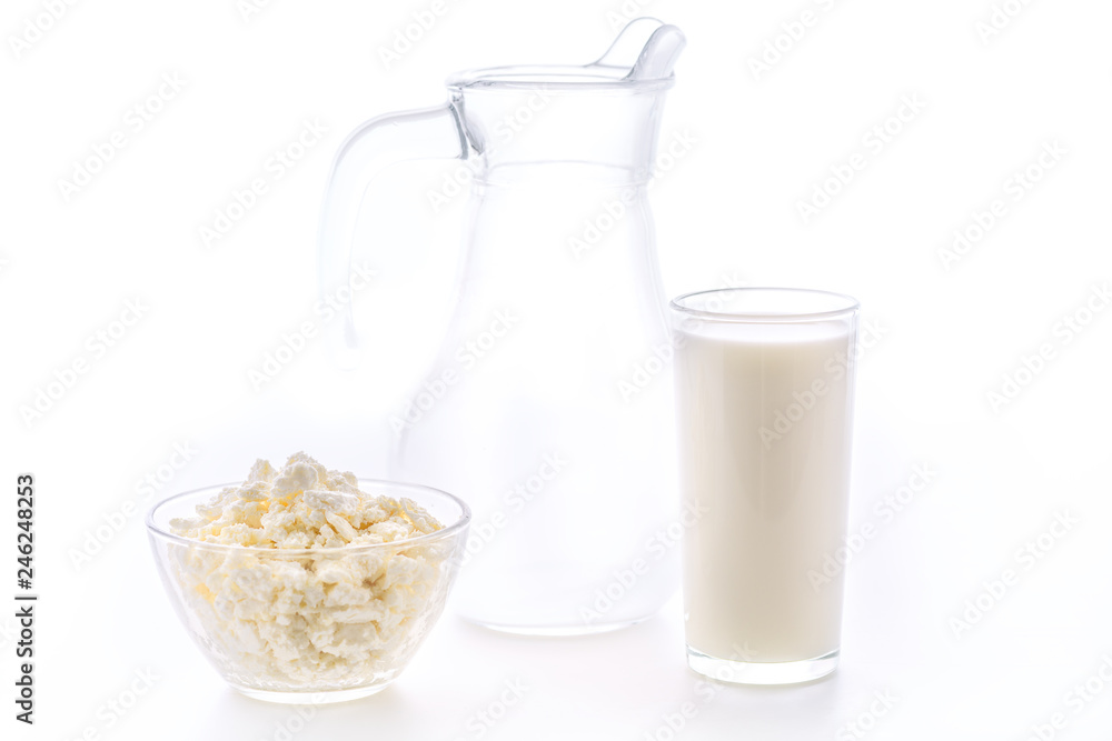 Fresh milk in a glass poured from a jug with a bowl of cottage cheese. Dairy products in the morning for breakfast are very healthy. Fresh milk in a glass poured from a jug with a bowl of cottage cheese. Dairy products in the morning for breakfast are very healthy.