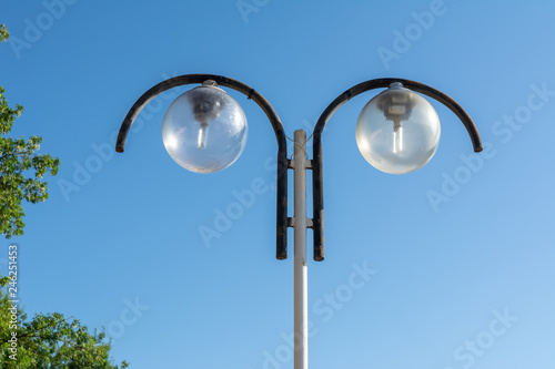 Street lamp with circular shades on the background of blue sky photo