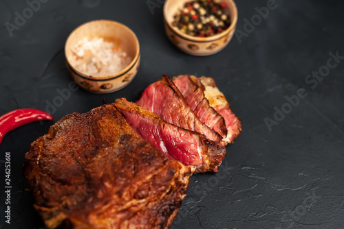 delicious steak, seasonings, a delicious piece of meat, cooked dinner on a concrete background