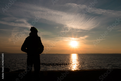 Silhoutte of young man enjoying the sunset.
