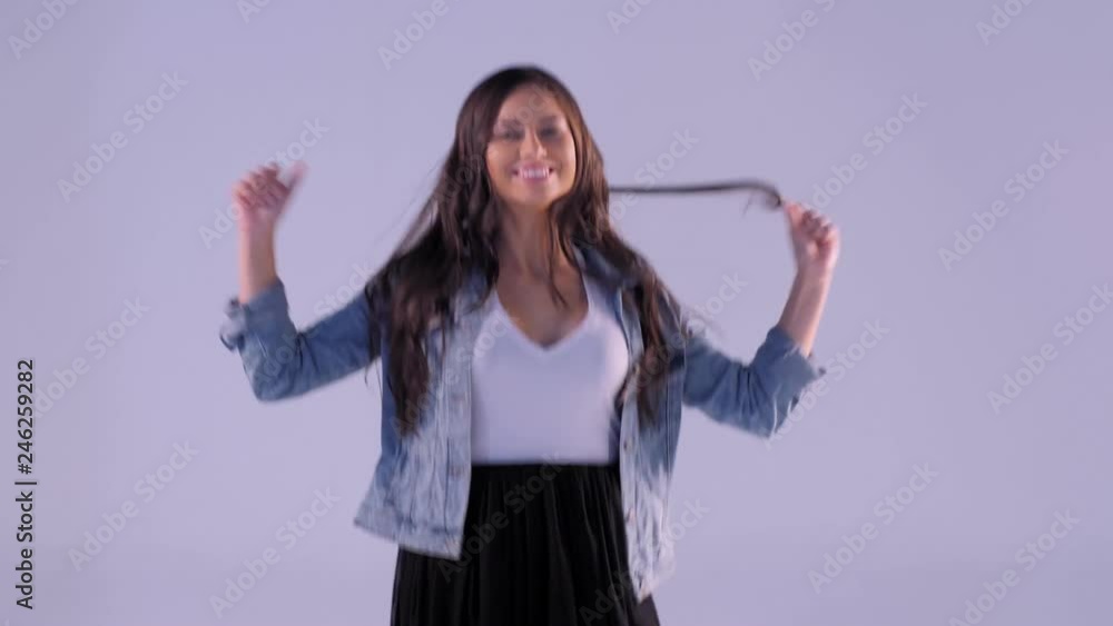 Cheerful young female model rising hands dancing and jumping posing at studio light background medium shot charming woman with long curly hair having good time indoor making positive emotions Cheerful young female model rising hands dancing and jumping posing at studio light background medium shot charming woman with long curly hair having good time indoor making positive emotions