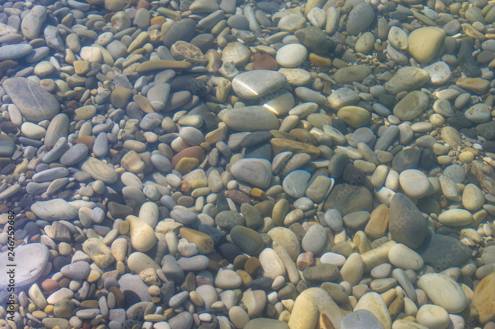 sea pebble beach with multicoloured stones, waves with foam sea pebble beach with multicoloured stones, waves with foam