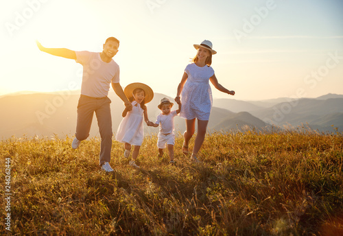 Happy family: mother, father, children son and daughter on sunset