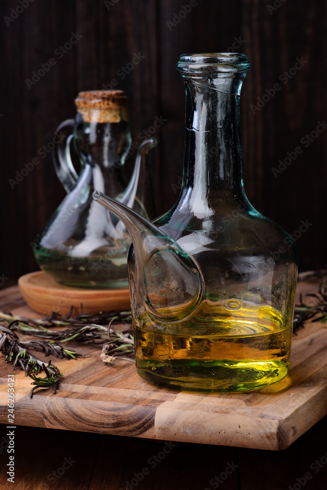 oil with Spanish olive oil of intense color and branches of rosemary on rustic wood oil with Spanish olive oil of intense color and branches of rosemary on rustic wood