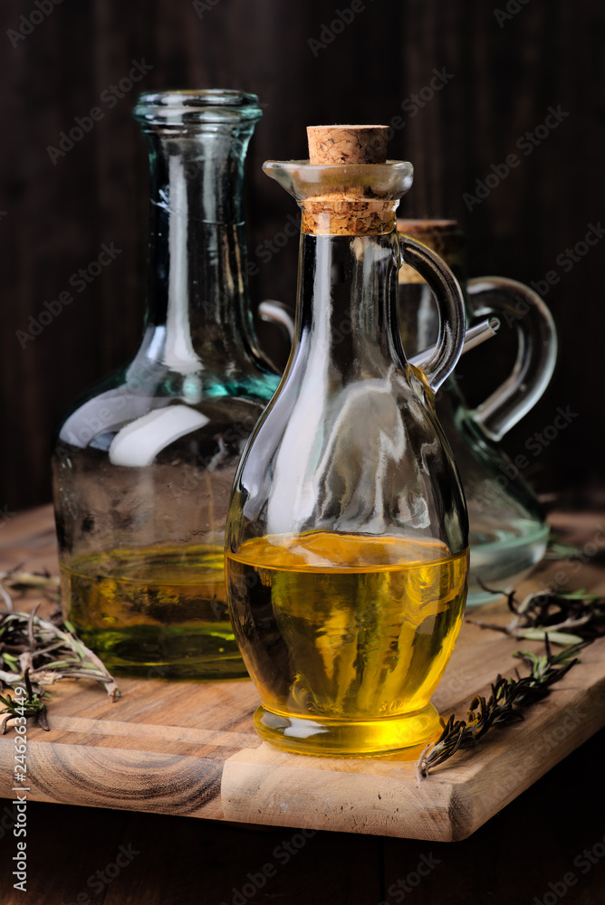 oil with Spanish olive oil of intense color and branches of rosemary on rustic wood oil with Spanish olive oil of intense color and branches of rosemary on rustic wood