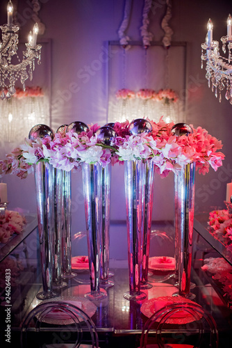 Fototapeta Naklejka Na Ścianę i Meble -  High end wedding tablescape with pillar candles and pink orchids and chandelier