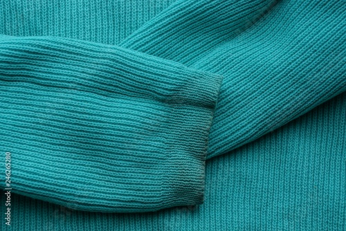 green fabric texture from green sweater with dirty sleeves