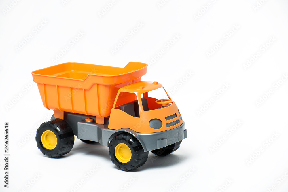 Plastic toy yellow truck on a white background. Close-up. Plastic toy yellow truck on a white background. Close-up.