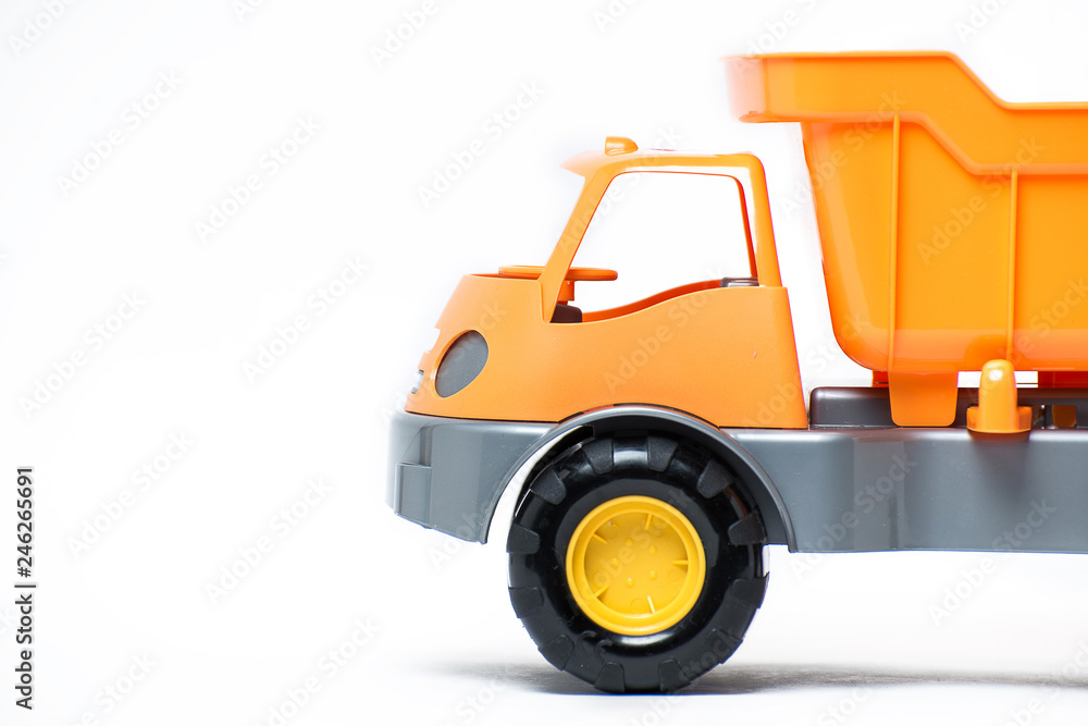  Plastic toy yellow truck on a white background. Close-up.