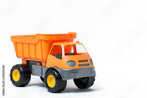  Plastic toy yellow truck on a white background. Close-up.