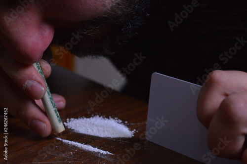 Tableau sur toile Person with a dollar bill snorting cocaine