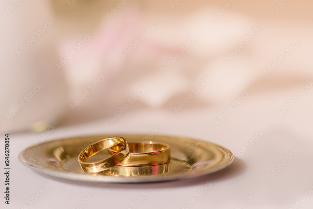 Wedding gold wedding rings on a small plate, close-up Wedding gold wedding rings on a small plate, close-up
