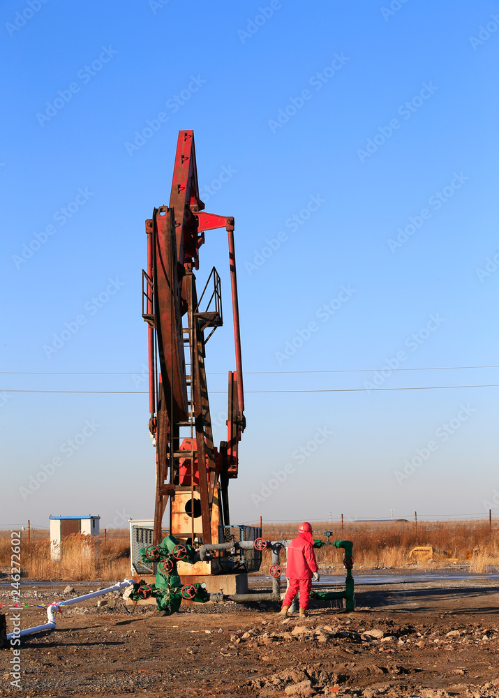 Pumping units at work in the blue sky background Pumping units at work in the blue sky background