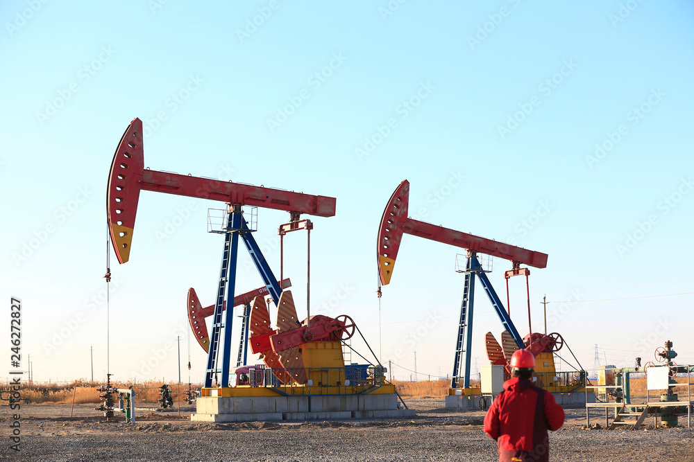 Pumping units at work in the blue sky background Pumping units at work in the blue sky background
