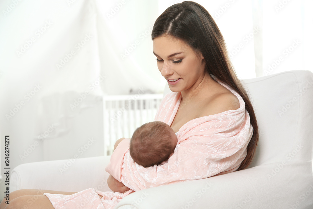 Young woman breastfeeding her baby in nursery. Space for text Young woman breastfeeding her baby in nursery. Space for text