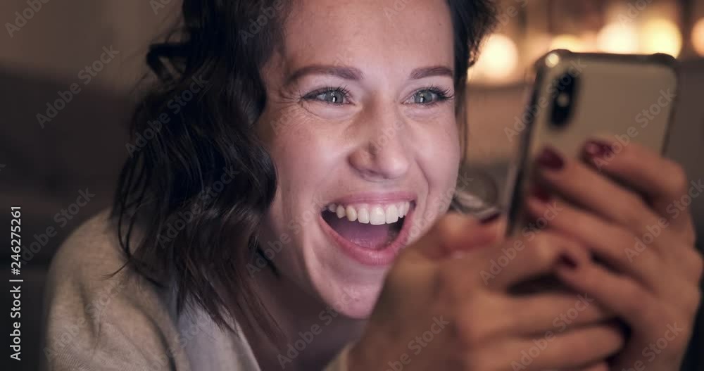 Happily surprised young woman using smart phone at night Happily surprised young woman using smart phone at night