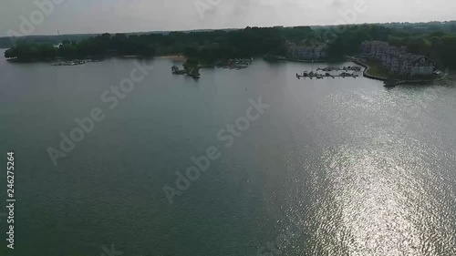 Aerial flyover lake with boat docks and beach. photo