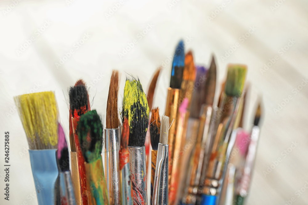Different paint brushes on light background, closeup Different paint brushes on light background, closeup