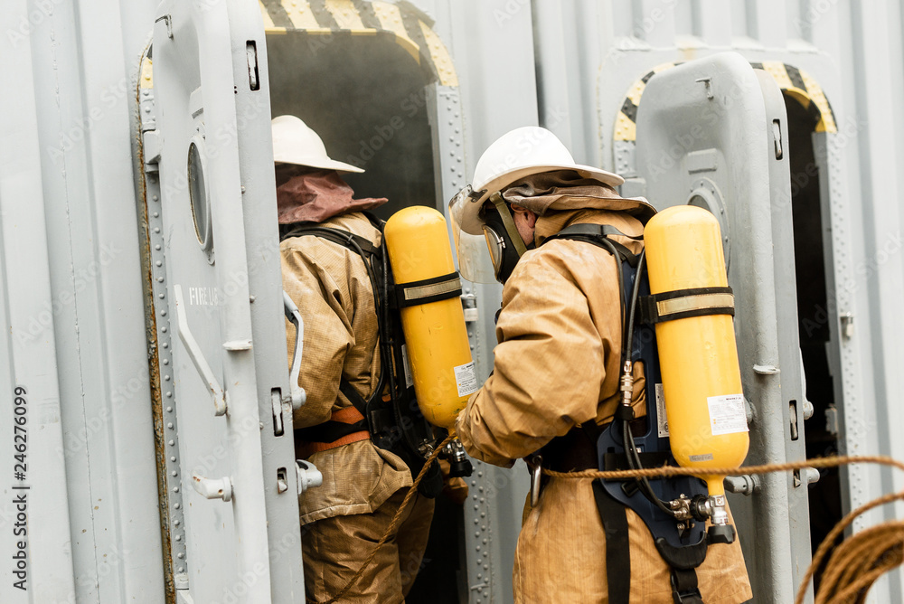 Firefighters on a ship in undeveloped countries use teamwork on a training how to stop fire in a dangerous mission and protect the environment