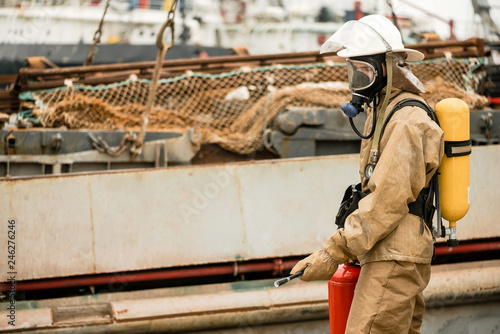 Firefighters in a sea port on a ship in undeveloped countries use teamwork on a training how to stop fire in a dangerous mission and protect the environment