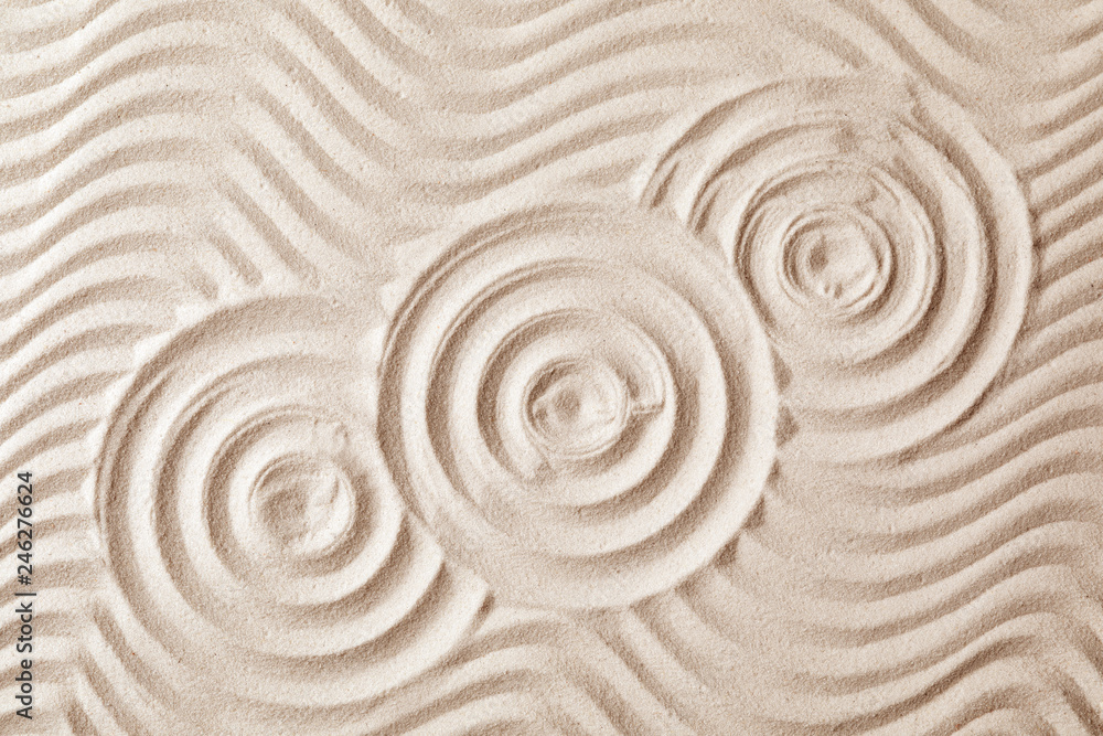 Fototapeta Zen garden pattern on sand as background, top view. Meditation and harmony