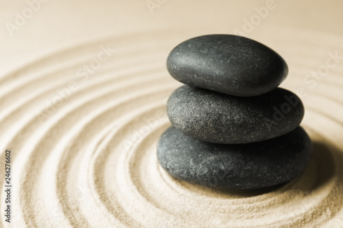 Stacked zen garden stones on sand with pattern  space for text. Meditation and harmony
